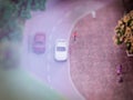 Blurred image of a street model with cars on the road, tiny people and trees. Blurred image