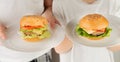 Blurred image of two boys holding white plates of burgers