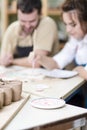 Blurred Image of Two Caucasian Ceramists Glazing Ceramic Clay Tiles Royalty Free Stock Photo