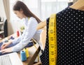 Blurred image of young Asian woman tailor's working on her desk. Selective focus of clothes and measure tape Royalty Free Stock Photo