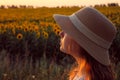 Blurred image of a young girl wearing a hat and looking to the side, beautiful sky bakground.