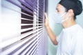 Blurred images of A man standing by the window wearing a surgical mask