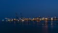 Blurred industry background with defocused cargo dock terminal in sea with colorful bokeh light at midnight. Urban and