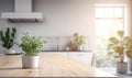 Blurred interior of a white kitchen with window, wooden countertop with a green plants Royalty Free Stock Photo