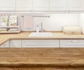 Blurred kitchen interior with wooden dinning table in front Royalty Free Stock Photo