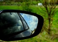 A dirty rearview mirror with reflections of the clouds Royalty Free Stock Photo