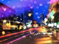 Blurred light at night city ,street bus traffic modern building and wet asphalt colorful light reflection night cars urban lif