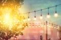 Blurred light on sunset with yellow string lights decor in beach restaurant Royalty Free Stock Photo
