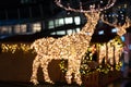 Blurred lights of christmas installation - defocused lights of deer on night city background. Christmas deer installation in Milan