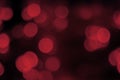 Blurred lights dark red, black background. Abstract bokeh. Shiny festive mysterious texture