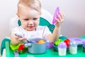 Blurred little child holding a toy vegetable in his hands on the background of dishes Royalty Free Stock Photo