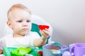 Blurred little child holding a toy vegetable in his hands on the background of dishes Royalty Free Stock Photo