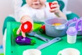 Blurred little child holding a toy vegetable in his hands on the background of dishes Royalty Free Stock Photo