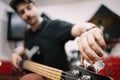 Blurred male musician tuning his electric guitar