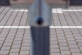 Blurred metal pipe on foreground. In the background, a white stripe on pavement Royalty Free Stock Photo