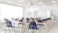 Blurred modern classroom interior with rows of desks and blue chairs Royalty Free Stock Photo