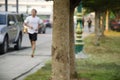 Asian thai people running jogging and exercise in dusk time at public garden park in Nonthaburi, Thailand.