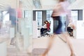 Blurred motion of businesswoman walking with colleagues working in background at office Royalty Free Stock Photo