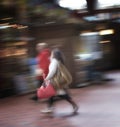 Blurred motion of a couple commuting through an urban town. Man and woman rushing while walking together in a street in Royalty Free Stock Photo