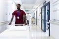 Blurred motion of diverse doctors and medical staff in busy hospital corridor, copy space Royalty Free Stock Photo