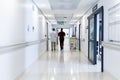 Blurred motion of diverse doctors walking in busy hospital corridor, copy space Royalty Free Stock Photo