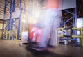 Blurred motion of forklift driver unloading shipment pallet goods in the warehouse storage Royalty Free Stock Photo