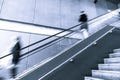 Blurred motion of people going down an escalator.