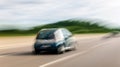 blurred in motion photography of small car driving on the highway Royalty Free Stock Photo