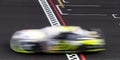 Blurred motion racing car crossing finish checkered line Royalty Free Stock Photo