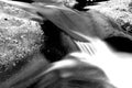 Blurred Motion and Slow Shutter Waterscape Photography of a River Rushing over a Stone. Royalty Free Stock Photo