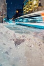 Blurred motion of tram in illuminated city, illuminated street at Night, snow covered street. Winter Weather Royalty Free Stock Photo