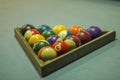 A blurred multicolored billiard balls on a blue table cloth in a wooden triangle. numbers on billiard balls