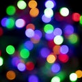 Blurred multicolored christmas lights on black background. Xmas backdrop for design or printing. New year square shape texture