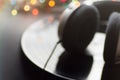 Blurred Music Background. Headphones Lying On Vintage Vinyl Long Play Record Black Background Multicolored Bokeh Lights