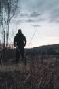 A blurred out of focus edit. A moody figure, back to camera, standing in the countryside looking at the evening sky. With a