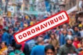 Blurred Overcrowded Street packed with people with Coronavirus text in red in the foreground