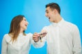 Blurred overjoyed couple with kwys to their new apartments, raising hands up, ready to move as soon as possible. Focus