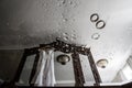 Blurred pair of rings is leaning on a glass covered with water droplets on the foreground. White wedding gown is hanging on a Royalty Free Stock Photo