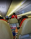 Blurred people playing her phone on the interior airplane