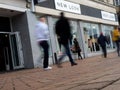 Shoppers walking past a New Look store blurred in motion