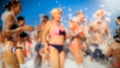 Blurred image of big crowd dancing on the sea beach on summer holiday vacation. People having fun and celebrating. Royalty Free Stock Photo