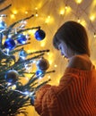 Blurred photo of cute little girl decorates christmas tree. Royalty Free Stock Photo