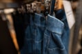 Blurred photo of denim pants in clothing store. Jeans on hanger hanging on rack in clothing store. Fashion retail shop inside Royalty Free Stock Photo