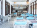 Blurred photo of interior restaurant view background with dining table set, chairs, blurry cafe, tropical style. Royalty Free Stock Photo