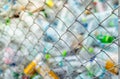 Blurred photo of pile of empty water plastic bottle in mesh fence recycle bin. Plastic bottle waste for recycle in recycling