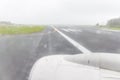 Blurred photo of rain drops from airplane window and airport run Royalty Free Stock Photo