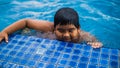 Blurred photo of a young asian happy kid swimming inside the swimming pool at the resort Royalty Free Stock Photo