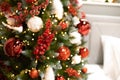 Blurred picture of christmas tree with led lights bokeh, baubles, balls, toys, holy berries on fir branches