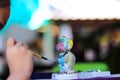 Blurred plaster monkey statue by asian child girl hand painting with paintbrush art color on background Royalty Free Stock Photo