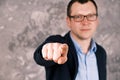 Blurry portrait of a young confident smiling modern businessman in glasses in a suit against the background of a gray Royalty Free Stock Photo